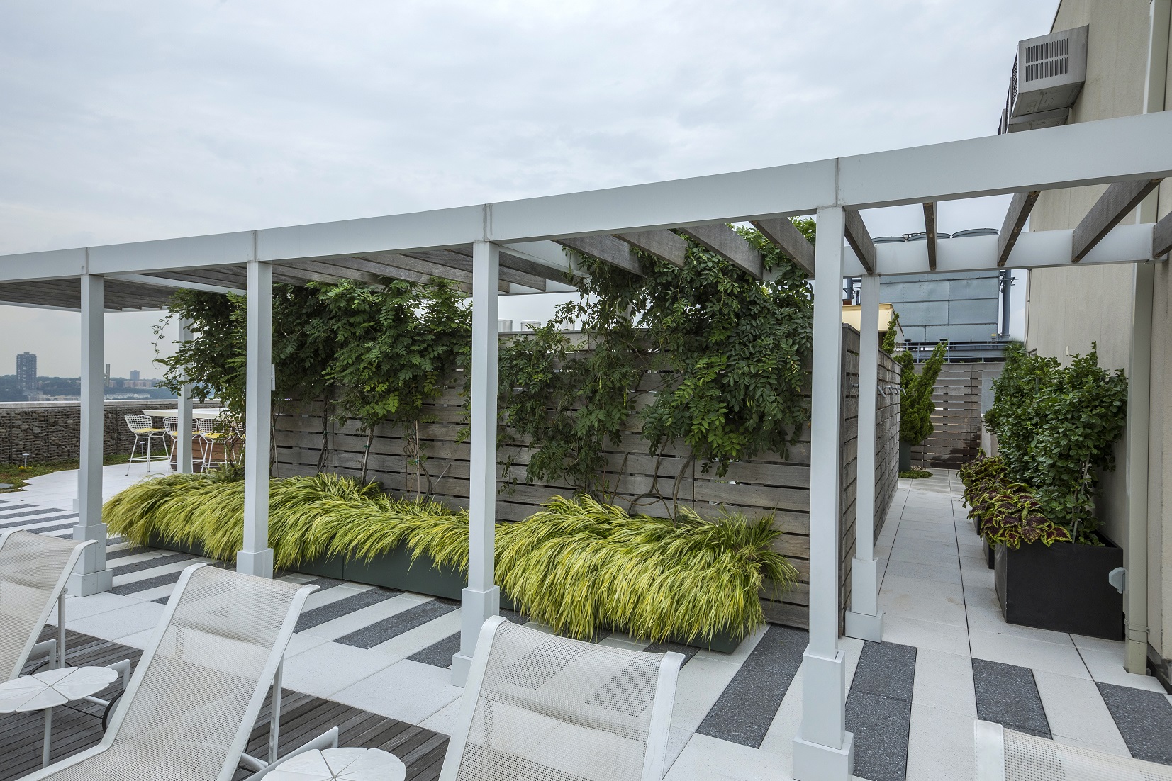 Expertly maintained specimen trees mix with perennials to encompass this sizeable outdoor rooftop, providing entertainment area