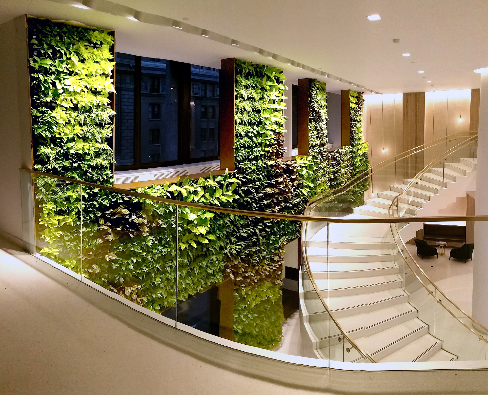 The juxtaposition of organic and rectilinear form of this living wall creates a dynamic backdrop for the centralized atrium and