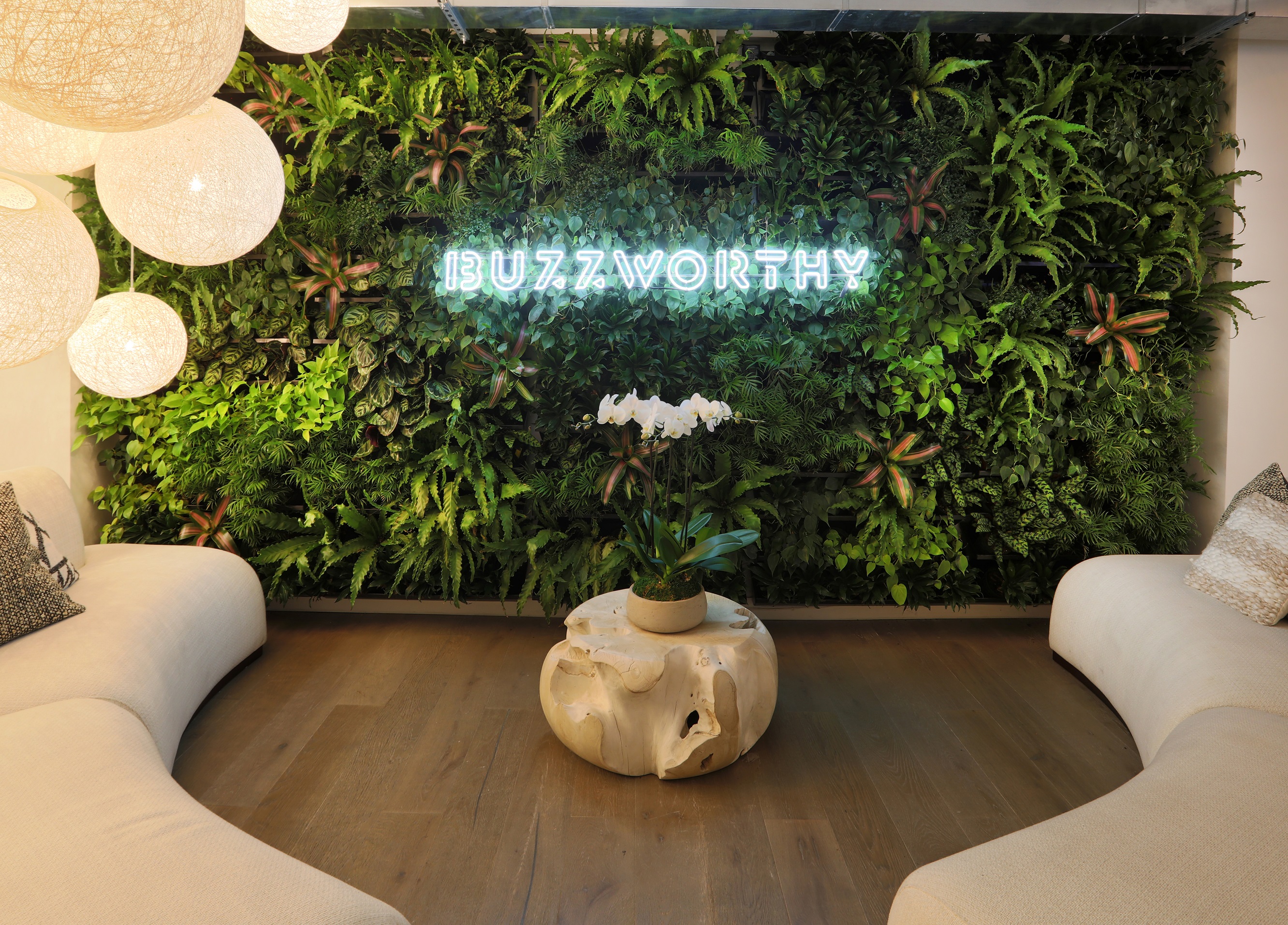 This luxurious living wall greets visitors upon entrance to the office space, nestled behind neon lettering to create a strong
