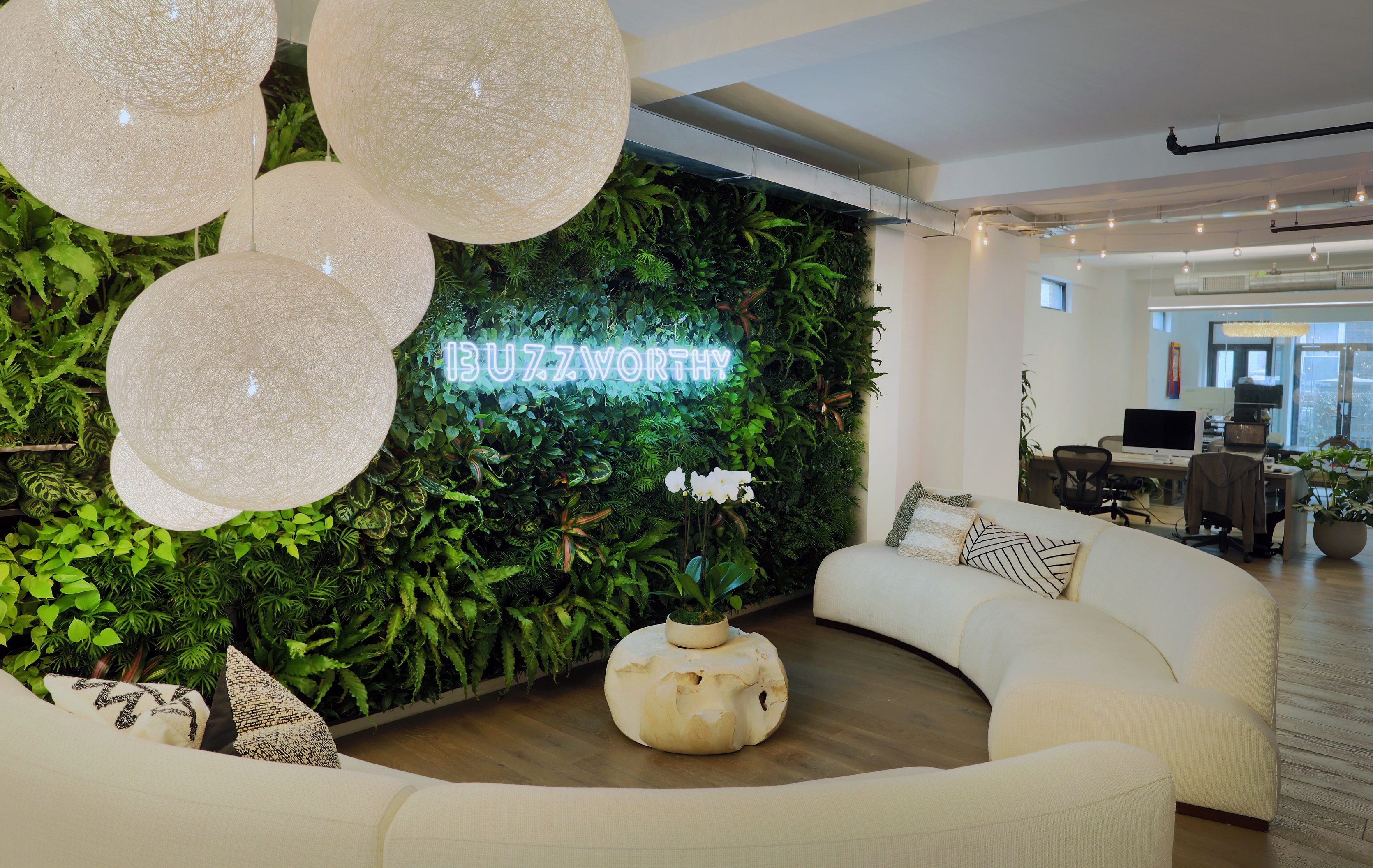 This luxurious living wall greets visitors upon entrance to the office space, nestled behind neon lettering to create a strong